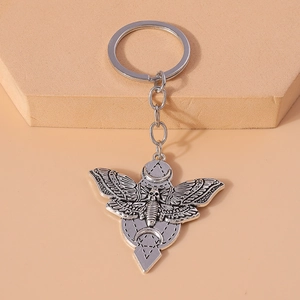 Gothic silver moth keychain featuring a skull design with crescent moon and geometric symbols