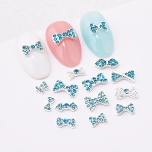 Detail of blue rhinestone bow nail charms with silver alloy base for manicure art