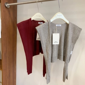 Detail of wool blend knitted shawls in burgundy and beige with premium fabric texture