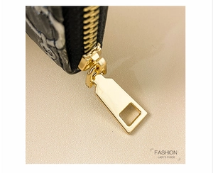 Macro detail of high-quality gold metal zipper and vintage monogram texture on long wallet