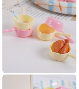 Miniature kitchen dollhouse set with pink and yellow plastic pots and play food drumsticks