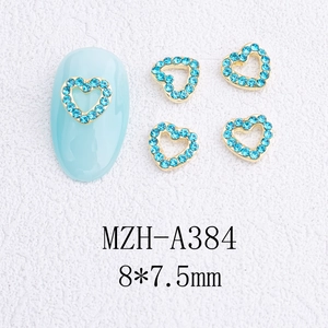 Vue détaillée de bijoux d'ongles cœur doré avec strass bleus sur un ongle bleu