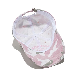 Detail of pink camo baseball cap interior showing embroidered cross and metal buckle