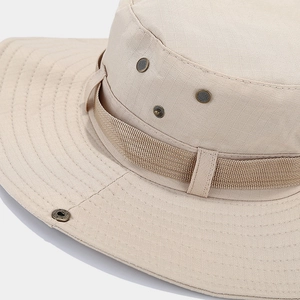 Detail of ripstop fabric and metal ventilation eyelets on a beige outdoor sun hat