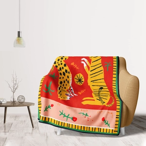 Artistic flannel blanket with floral tiger design draped over a sofa in a modern room