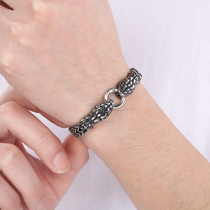 Close-up of double serpent head clasp on a silver snake scale chain bracelet