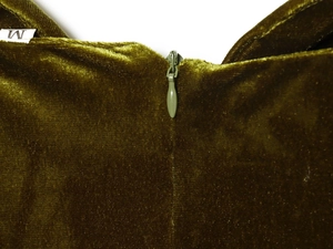 Detailed macro view of invisible zipper closure on luxury moss green velvet dress fabric
