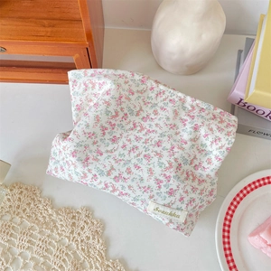 Detailed close-up of floral makeup bag with Sezakka label and soft cotton texture