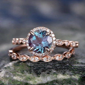 Elegant rose gold wedding ring set with round alexandrite stone on natural mossy rock