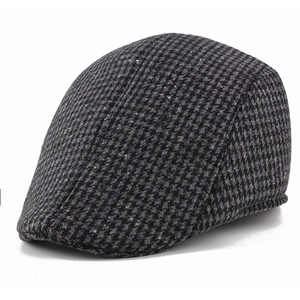 Detail of classic black and grey houndstooth pattern on warm brushed wool flat cap