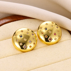 Close-up of golden star-patterned stud earrings with multi-colored gemstone inlays