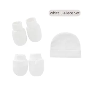 Detailed view of white 3-piece newborn set including soft cotton baby hat and mittens