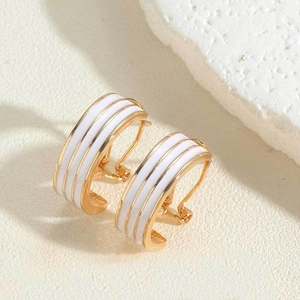 Detail of 14K gold plated C-shaped earrings with white enamel stripes and 925 silver post