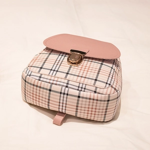Dettaglio dello zaino a scacchi rosa e beige con fibbia in metallo dorato