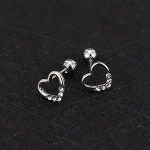 Detailed macro view of silver heart stud earrings with zircons and screw ball backs