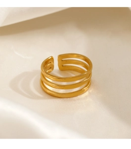 Detailed close-up of a triple-layered gold stainless steel ring on soft silk background