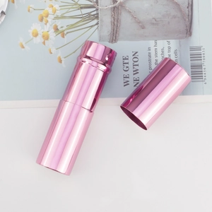 Detail of pink metallic retractable makeup brush tube on a magazine background