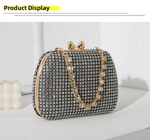 Detail of luxury rhinestone clutch bag featuring heart clasp and gold metal chain