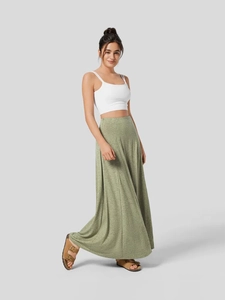 Women's green high waist long knit skirt paired with a white cropped camisole top