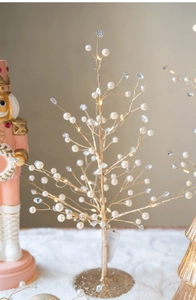 Close-up of LED lit golden Christmas tree with white pearls and clear crystal beads