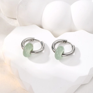 Detailed macro of stainless steel hoop earrings with green natural stone beads