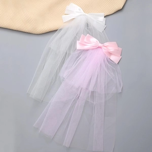 Elegant white and pink bridal bow hair veils with layered mesh on a minimalist background