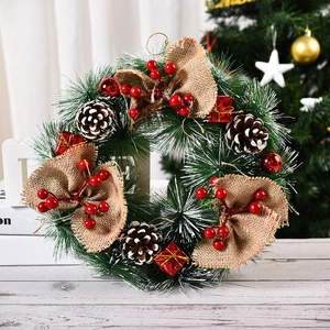 Detail of Christmas wreath with pine needles, cones, berries and a burlap bow