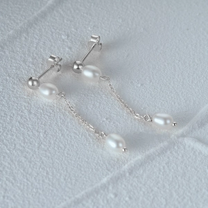 Detailed macro shot of S925 sterling silver chain earrings with white oval pearls