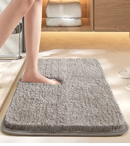 Close-up of soft grey plush bathroom mat showing foot pressure for texture and absorbency