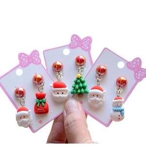 Close-up of children's Christmas clip-on earrings featuring Santa and Snowman themes