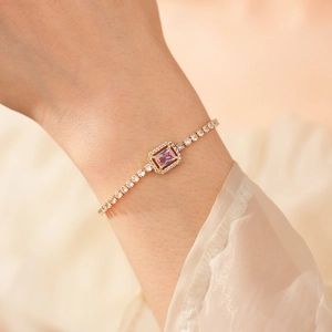 Detail of elegant gold bracelet with pink zirconia stone and pave crystals on wrist