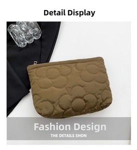 Detail of brown quilted floral pattern with golden zipper on a stylish vanity bag