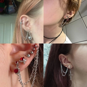 Detailed views of punk style earrings with red heart gems and silver cross chains