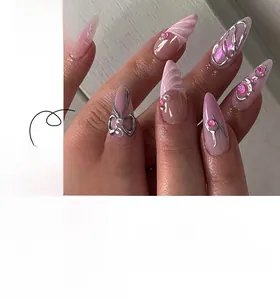 Gros plan d'ongles roses à presser avec nœuds argentés 3D et perles décoratives