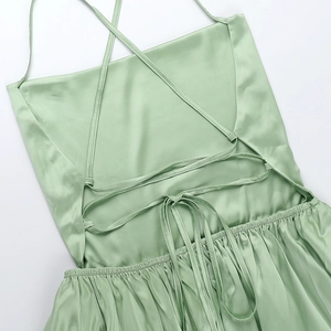 Detail view of light green satin dress featuring adjustable criss-cross back straps