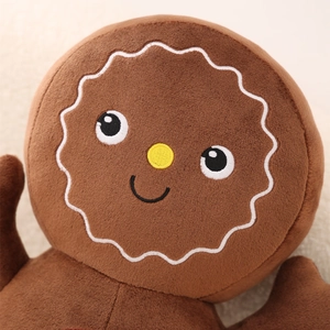 Close-up of cute gingerbread man plush toy head with detailed white embroidery accents