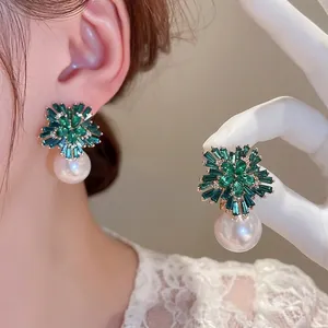 Elegant gold flower earrings with green cubic zirconia and round white pearls