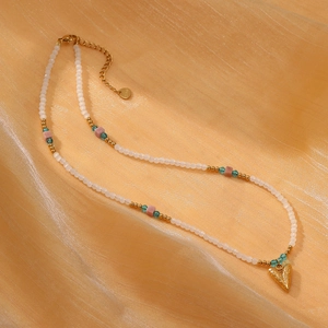 Macro detail of sunflower rhodochrosite beaded necklace with golden heart pendant