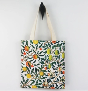 Detail of William Morris fruit pattern canvas tote bag hanging on a minimalist wall hook