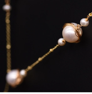 Macro shot of natural freshwater pearl with intricate gold wire wrapping detail