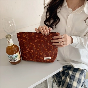 Détails d'une pochette en velours côtelé à fleurs avec étiquette tissée soignée