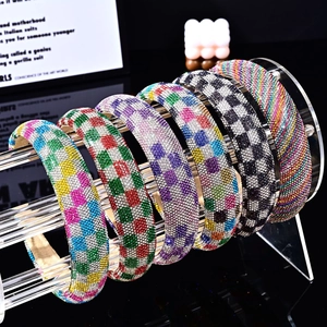 Set of six colorful rhinestone headbands with checkered patterns on a display stand