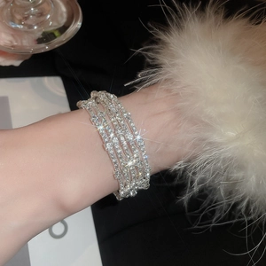 Dettaglio di un elegante bracciale multistrato con strass scintillanti indossato da una modella