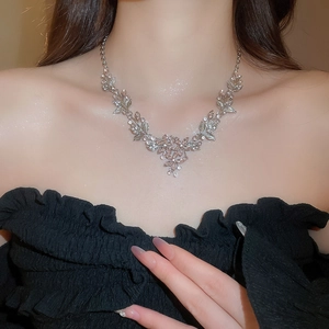 Close-up of sparkling diamond-set flower leaf pendant necklace on model neck