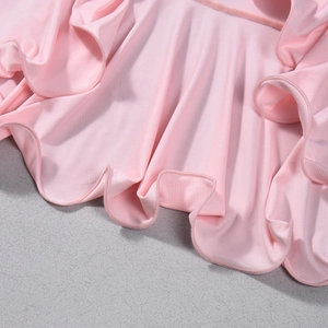 Gros plan d'une robe rose montrant la texture douce du tissu et les bords à volants