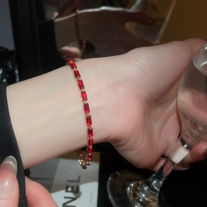 Detailed macro of 18k gold ruby bracelet with rectangular gems in claw setting