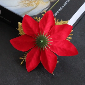 Close-up of red velvet artificial poinsettia with gold glitter leaves for Christmas tree