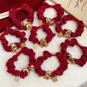 Détail de chouchous rouges festifs avec breloques dorées du zodiaque chinois