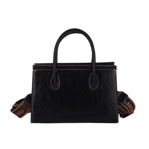 Retro black leather tote bag with contrast stitching and wide brown shoulder strap
