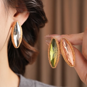 Detailed view of marquise-cut crystal earrings in olive green, peach, and clear crystals